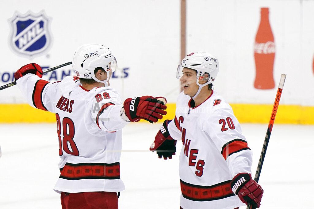 Wilfredo Lee Carolina Hurricanes center Martin Necas (88) is congratulated by center Sebastian Aho (20) after Necas scored the winning goal during an overtime period of an NHL hockey game against the Florida Panthers, Monday, March 1, 2021, in Sunrise, Fla. (AP Photo/Wilfredo Lee)