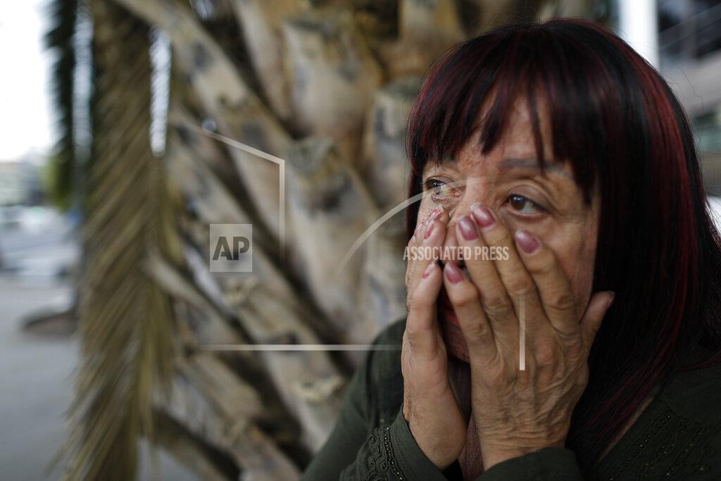 Rebecca Blackwell Sex worker Laura cries as she talks about having to pawn her cell phone the day before in order to eat, after running out of money to pay for her rented room at the end of February, as she waits for clients outside the Revolution subway station, in Mexico City, Sunday, March 14, 2021. After more than 45 years as a street sex worker, Laura, 62, says she has known a new level of poverty since the pandemic began. "I have lived many beautiful times, and now sad ones. But I'm still living." (AP Photo/Rebecca Blackwell)