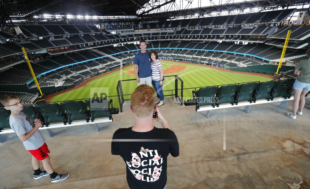 Lm Otero Baseball fans Mark Southard, center left, and his wife Janelle Southard, pose for a photo taken by their son Grayson, 16, as his brother, Gavin, 10, looks on during a tour of Globe Life Field, home of the Texas Rangers baseball team during the first day of public tours in Arlington, Texas, Monday, June 1, 2020. The family drove from their home in Wichita Falls, Texas, to see the team's new home field. (AP Photo/LM Otero)