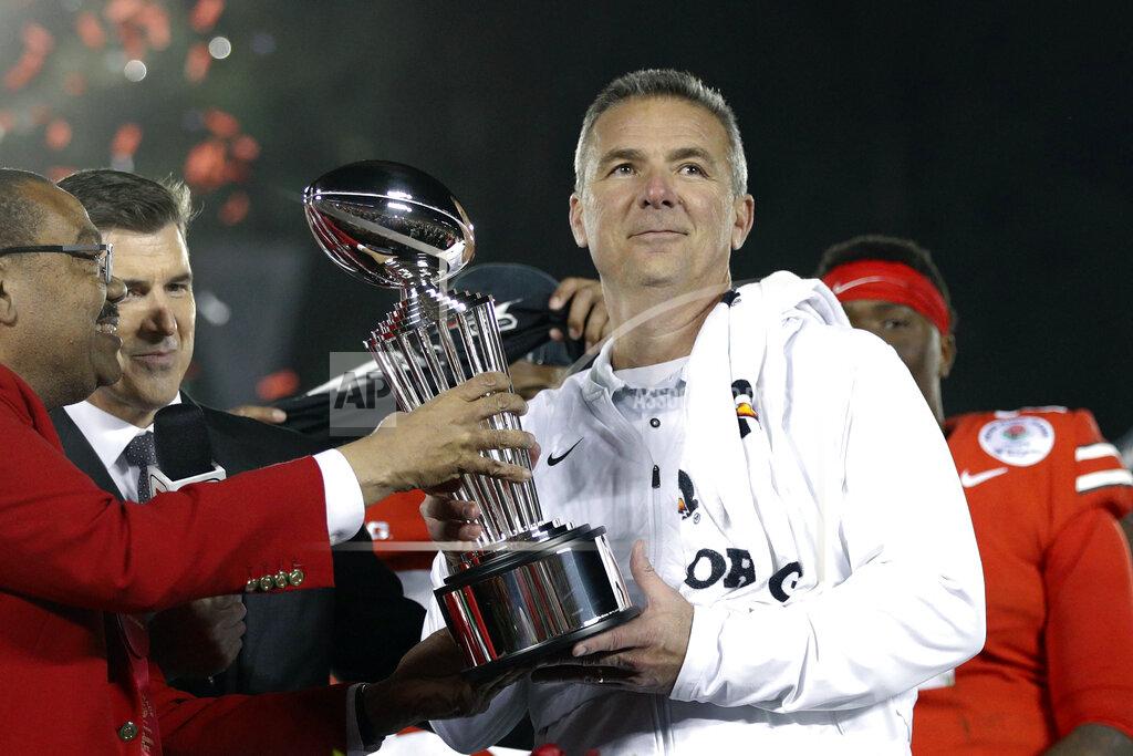 Jae C. Hong FILE - Ohio State coach Urban Meyer, right, holds the trophy after the team's 28-23 win over Washington in the Rose Bowl NCAA college football game in Pasadena, Calif., in a Tuesday, Jan. 1, 2019, file photo. A person familiar with the search says Urban Meyer and the Jacksonville Jaguars are working toward finalizing a deal to make him the team's next head coach. The person spoke to The Associated Press on the condition of anonymity Thursday, Jan. 14, 2021, because a formal agreement was not yet in place. (AP Photo/Jae C. Hong, File)