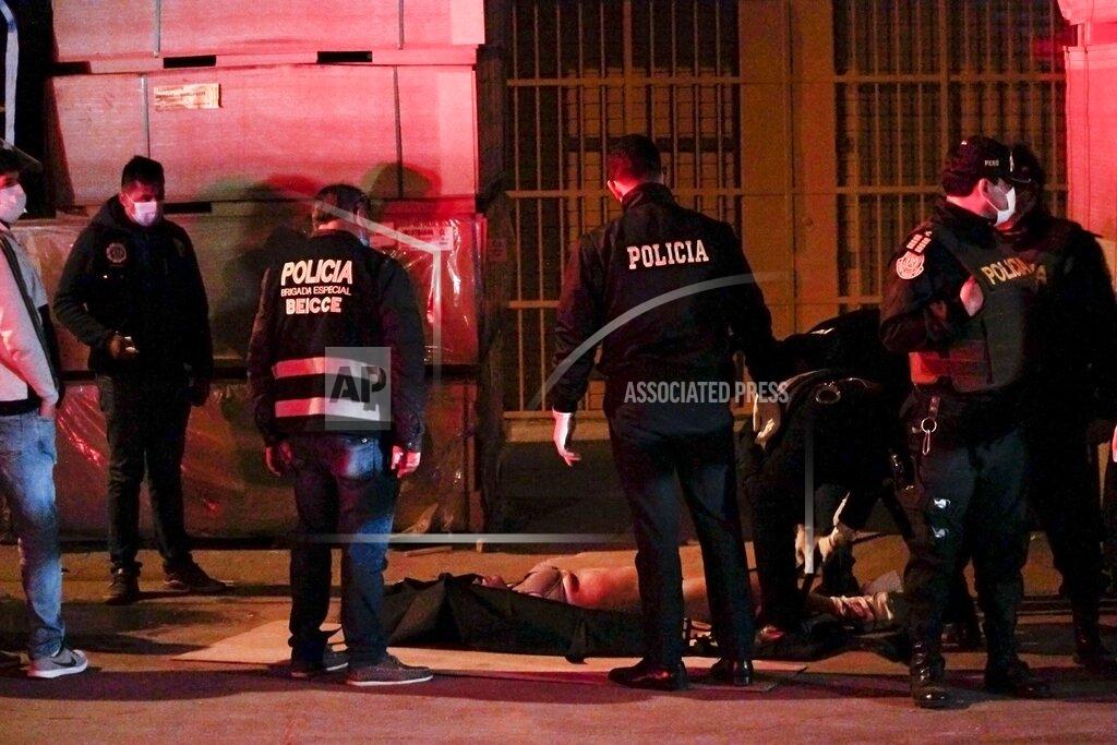 Diego Vertiz EDS NOTE: NUDITY - Police officers check a body of a victim outside a disco in Lima, Peru, Sunday, Aug. 23, 2020. Officials said over a dozen people died in a stampede at the disco after a police raid to enforce the country's lockdown during the coronavirus pandemic. (AP Photo/Diego Vertiz)