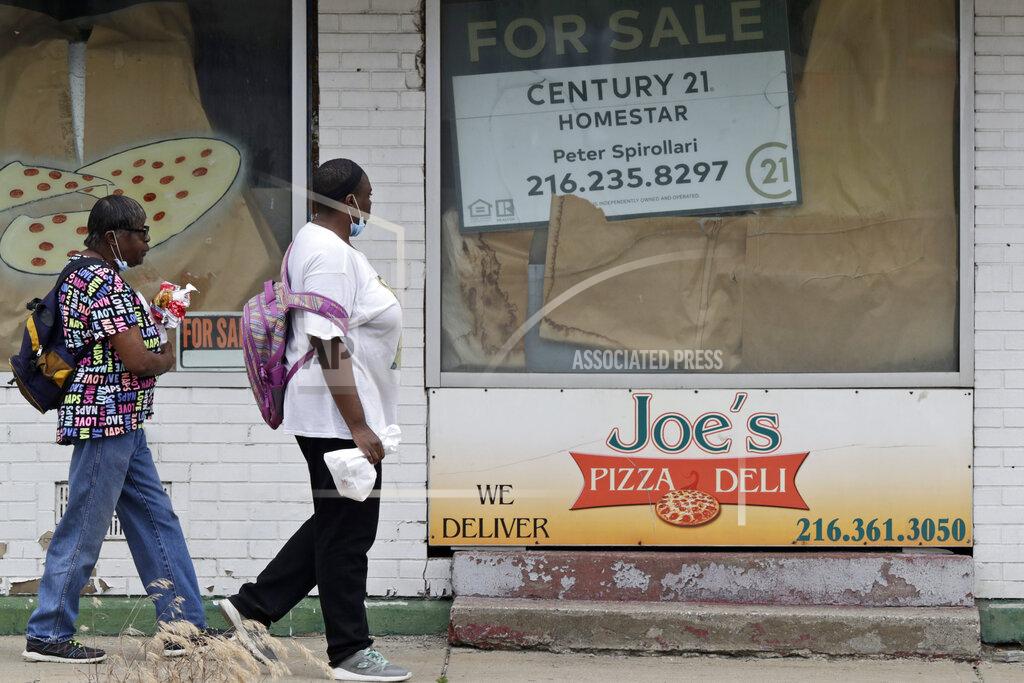 Tony Dejak Two women walks past a closed down pizza deli, Thursday, June 4, 2020, in Cleveland. The state says more than 34,000 Ohioans filed unemployment claims during the last week of May. That is the lowest figure since Ohio's stay-at-home orders depressed the economy and led to widespread layoffs. The figure released Thursday by the Ohio Department of Job and Family Services is down from about 46,000 claims filed the previous week. (AP Photo/Tony Dejak)