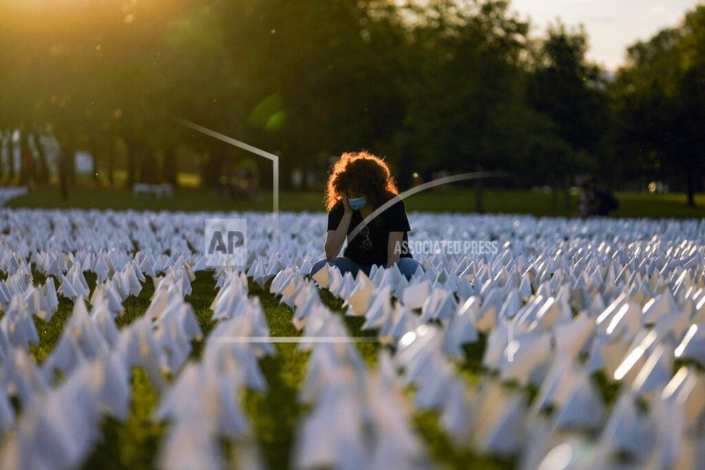 Brynn Anderson Zoe Nassimoff, of Argentina, looks at white flags that are part of artist Suzanne Brennan Firstenberg's temporary art installation, "In America: Remember," in remembrance of Americans who have died of COVID-19, on the National Mall in Washington, Friday, Sept. 17, 2021. Nassimoff's grandparent who lived in Florida died from COVID-19. (AP Photo/Brynn Anderson)