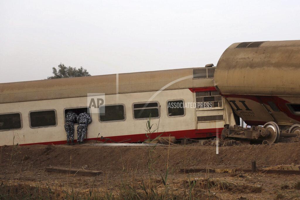 Fadel Dawood Security forces look inside a passenger train that derailed injuring some 100 people, near Banha, Qalyubia province, Egypt, Sunday, April 18, 2021. At least eight train wagons ran off the railway, the provincial governor's office said in a statement. (AP Photo/Fadel Dawood)