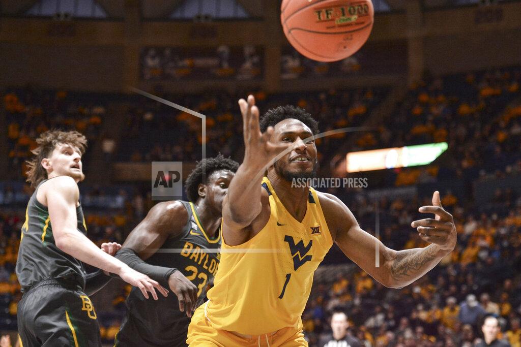 William Wotring West Virginia forward Pauly Paulicap (1) loose the ball while being guarded by Baylor forward Jonathan Tchamwa Tchatchoua (23) during the first half of an NCAA college basketball game in Morgantown, W.Va., Tuesday, Jan. 18, 2022. (William Wotring)