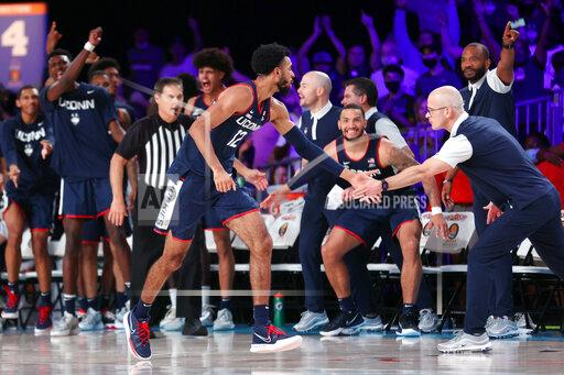Connecticut forward Tyler Polley (12) is congratulated by coach Dan Hurley after making a 3-point basket against Auburn in the second overtime of an NCAA college basketball game at Paradise Island, Bahamas, Wednesday, Nov. 24, 2021. (Tim Aylen/Bahamas Visual Services via AP)