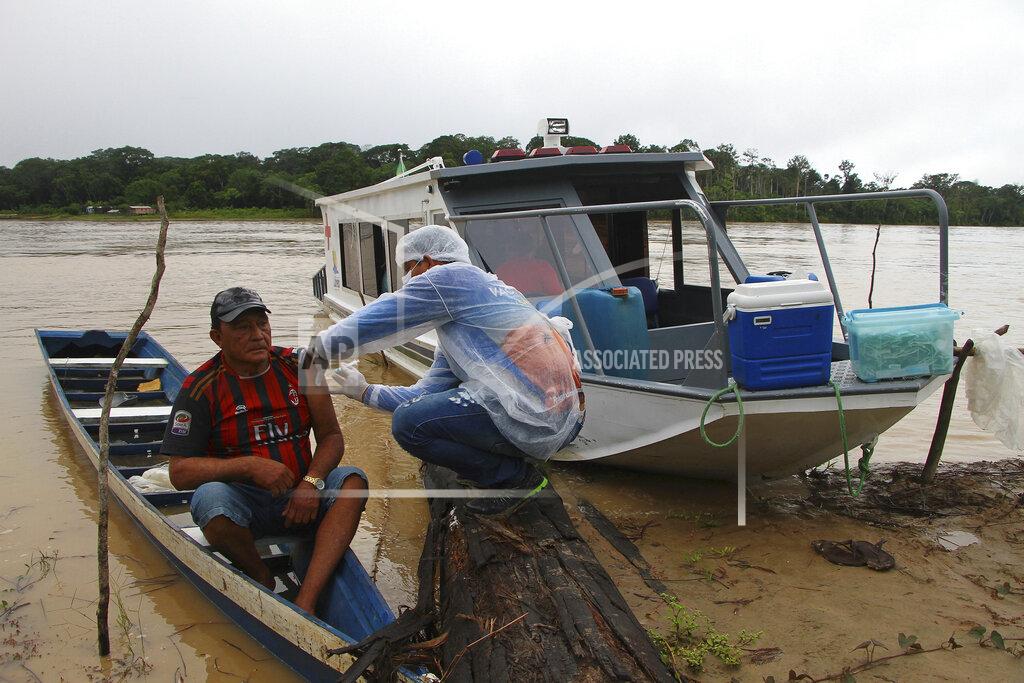 Luis Alves Nogueira, 74, left, receives a dose of the Oxford-AstraZeneca COVID-19 vaccine from a healthcare worker, in the Pupuri community along the Purus River, in the Labrea municipality, Amazonas state, Brazil, Friday, Feb. 12, 2021. Getting the vaccine to the world's farthest corners means delivering it by boat to Maine's islands, traveling by snowmobile to villages in Alaska and navigating complex waterways in Brazil's Amazon. (AP Photo/Edmar Barros)