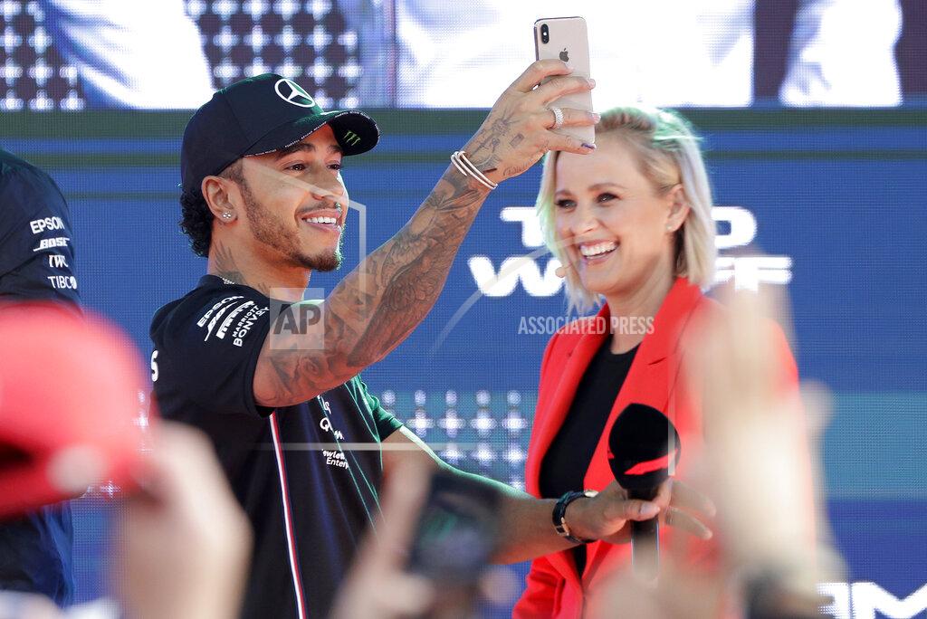 Rick Rycroft Mercedes driver Lewis Hamilton of Britain uses his phone as he arrives for the launch of the Australian Grand Prix in Melbourne, Australia, Wednesday, March 13, 2019. (AP Photo/Rick Rycroft)