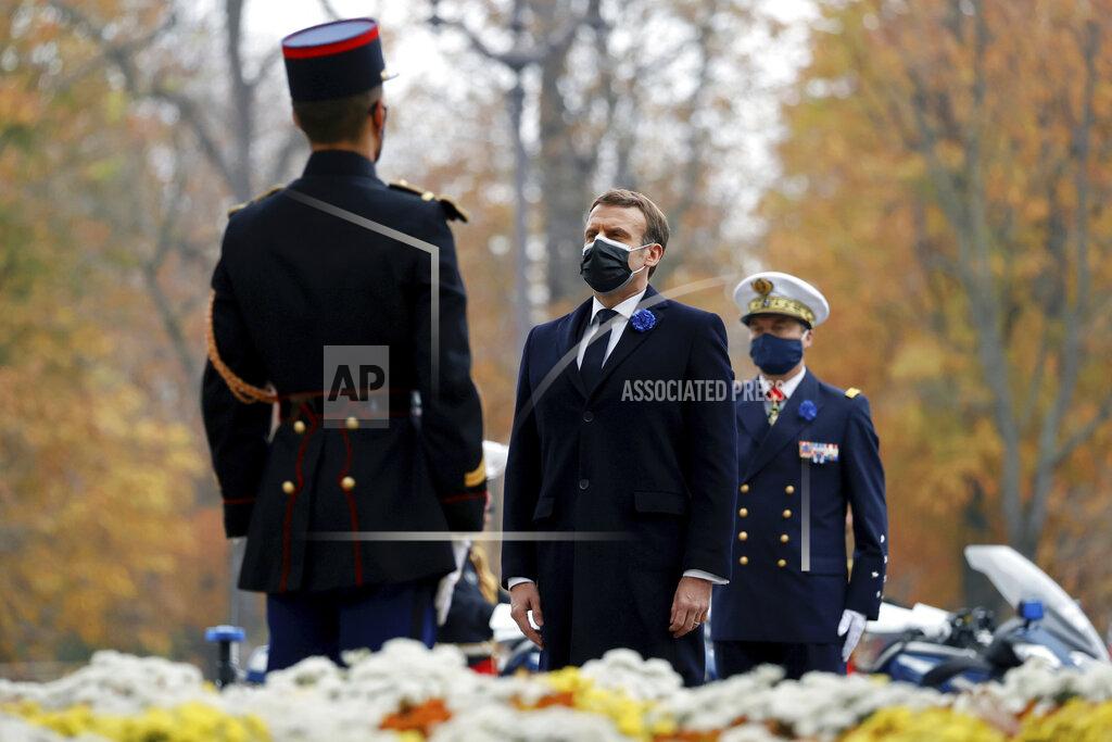 Christian Hartmann French President Emmanuel Macron, center, stands after laying a wreath in front of the statue of Georges Clemenceau, during the Armistice Day ceremonies marking the end of World War I, in Paris, Wednesday, Nov. 11, 2020. French President Emmanuel Macron is commemorating the 102nd anniversary of the armistice ending World War I and honoring all those who have died for France in two elaborate, solemn ceremonies Wednesday. (Christian Hartmann/Pool via AP)