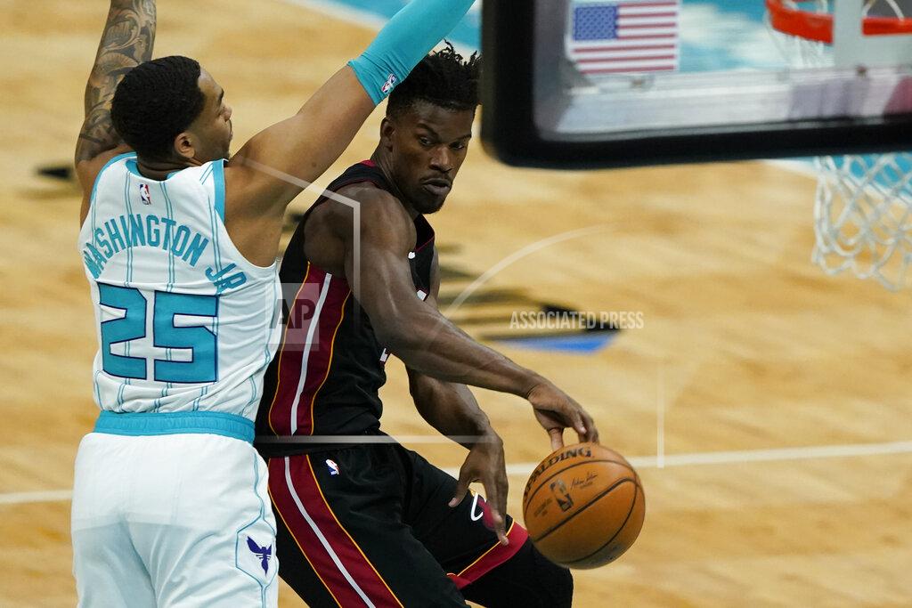 Chris Carlson Miami Heat forward Jimmy Butler, right, passes around Charlotte Hornets forward P.J. Washington during the first half of an NBA basketball game on Sunday, May 2, 2021, in Charlotte, N.C. (AP Photo/Chris Carlson)