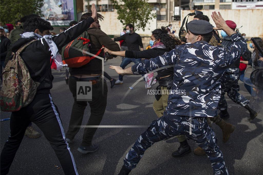 Hassan Ammar Riot police and army soldiers scuffle with anti-government protesters outside a military court in Beirut, Lebanon, Monday, Feb. 8, 2021. Riot police briefly clashed Monday in Beirut with hundreds of protesters demanding the release of anti-government activists detained following riots in northern Lebanon late last month. (AP Photo/Hassan Ammar)