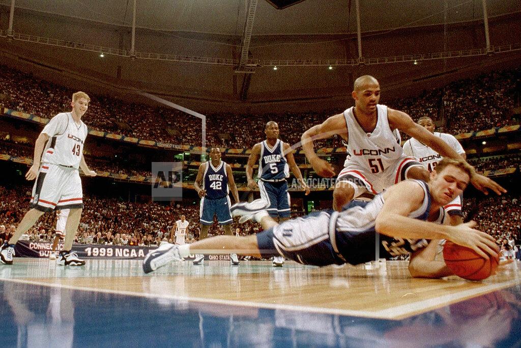 Dave Martin FILE - In this March 29, 1999, file photo, Duke's Chris Burgess tries to keep the ball from going out of bounds as Connecticut's Edmund Saunders (51) watches in the first half of the championship game of the NCAA college basketball Final Four, in St. Petersburg, Fla. UConn won 77-74. (AP Photo/Dave Martin, File)