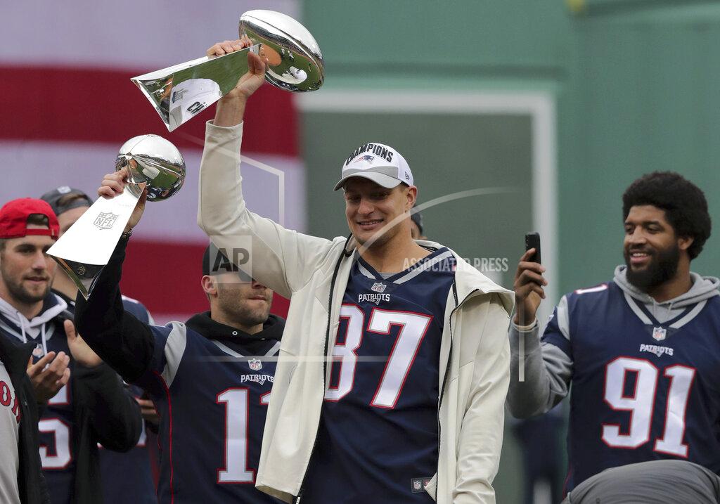 Charles Krupa New England Patriots' Julian Edelman (11) and Rob Gronkowski (87) lift Super Bowl trophies between Danny Etling, left, and Deatrich Wise, right, before the home opener baseball game between the Red Sox and the Toronto Blue Jays, Tuesday, April 9, 2019, in Boston. (AP Photo/Charles Krupa)
