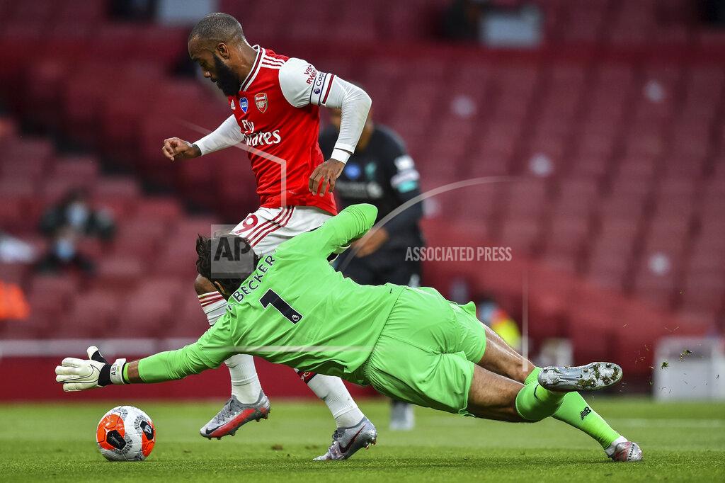 Glyn Kirk Arsenal's Alexandre Lacazette runs past Liverpool's goalkeeper Alisson before scoring his team first goal during the English Premier League soccer match between Arsenal and Liverpool at the Emirates Stadium in London, England, Wednesday, July 15, 2020. (Glyn Kirk/Pool via AP)
