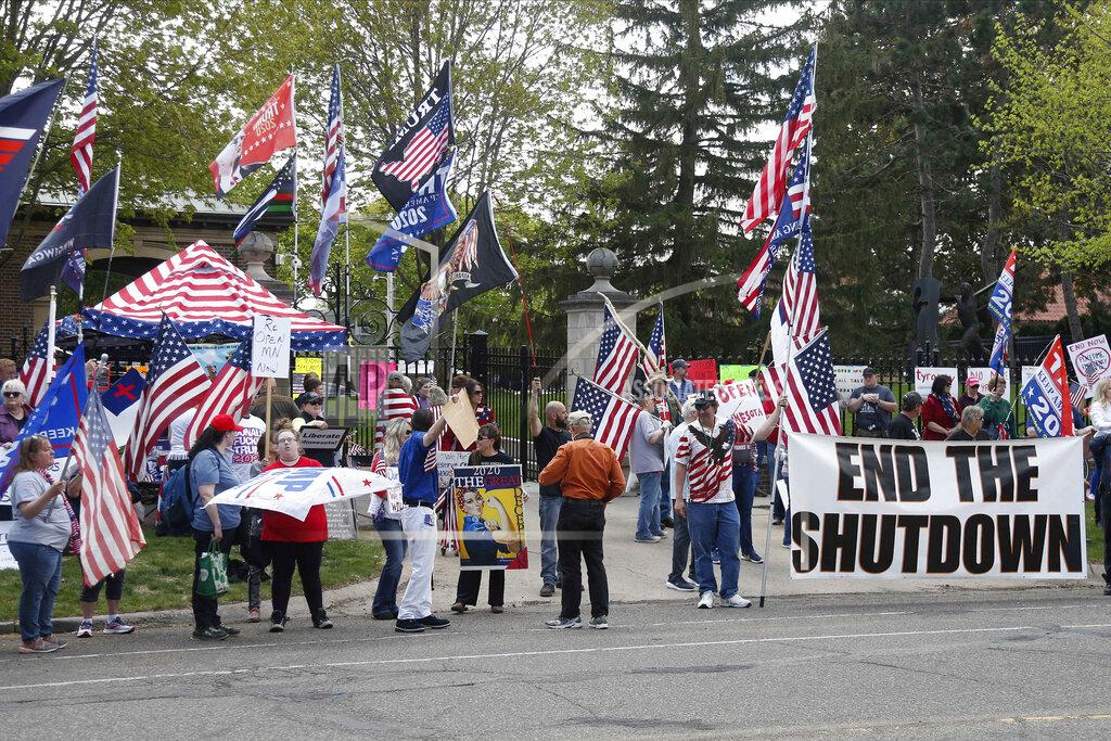 Protesters gather outside Minnesota Gov. Tim Walz' official residence Thursday, May 14, 2020, in St. Paul, Minn., to call on him to loosen restrictions imposed across the state because of the coronavirus. The governor announced Wednesday evening a number of changes which will take effect Monday. (AP Photo/Jim Mone)