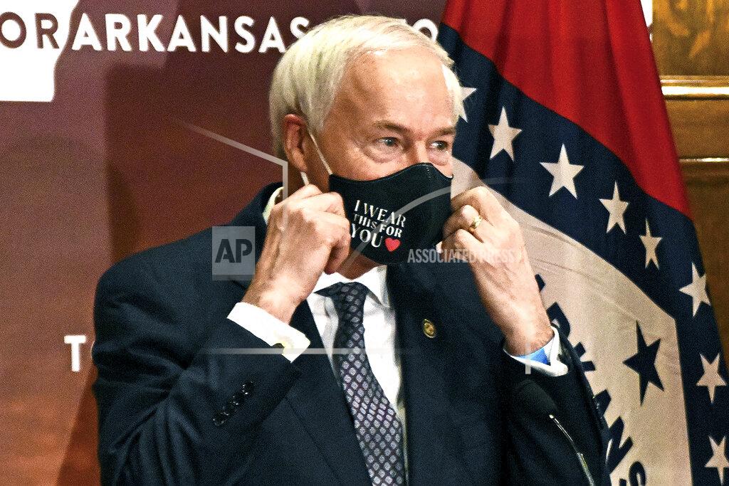 FILE - In this July 20, 2020 file photo, Arkansas Gov. Asa Hutchinson removes his mask before a briefing at the state capitol in Little Rock. Hutchinson has signed into law a measure that would allow doctors to refuse to treat someone because of moral or religious objections. Gov. Hutchinson on Friday, March 26, 2021, signed the legislation, despite objections that it would give medical providers broad powers to turn away LGBTQ patients and others. (Staci Vandagriff/The Arkansas Democrat-Gazette via AP, File)