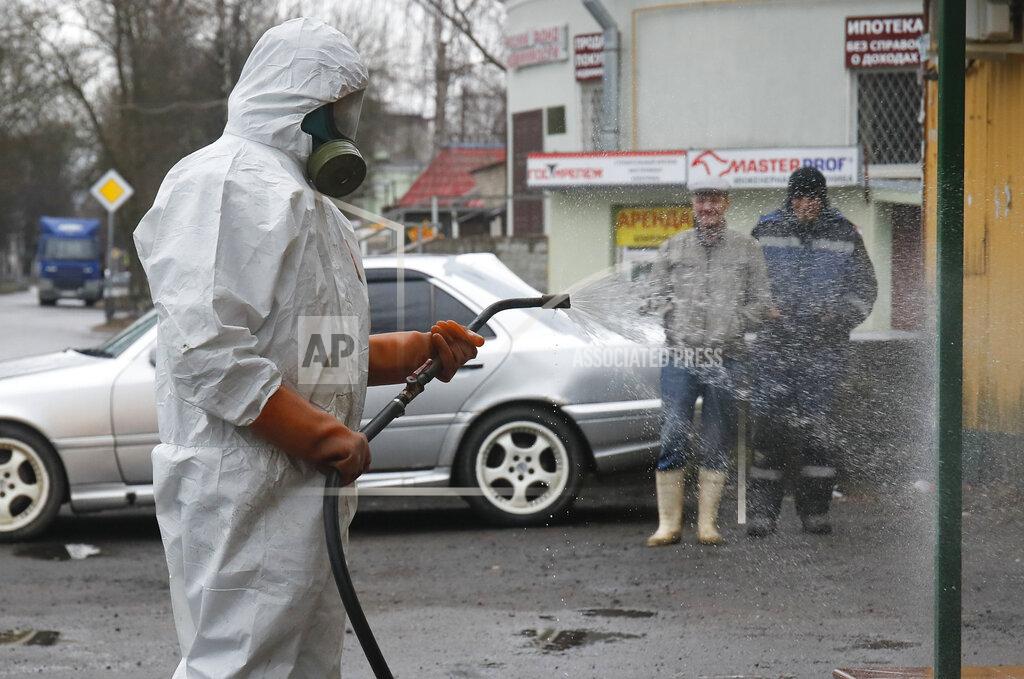 Dmitri Lovetsky A specialist from a local veterinary service wears a protective suit as sprays disinfectant near a food shop in Kirovsk, about 30 kilometres (19 miles) east of St.Petersburg, Russia, Thursday, April 2, 2020. The new coronavirus causes mild or moderate symptoms for most people, but for some, especially older adults and people with existing health problems, it can cause more severe illness or death. (AP Photo/Dmitri Lovetsky)