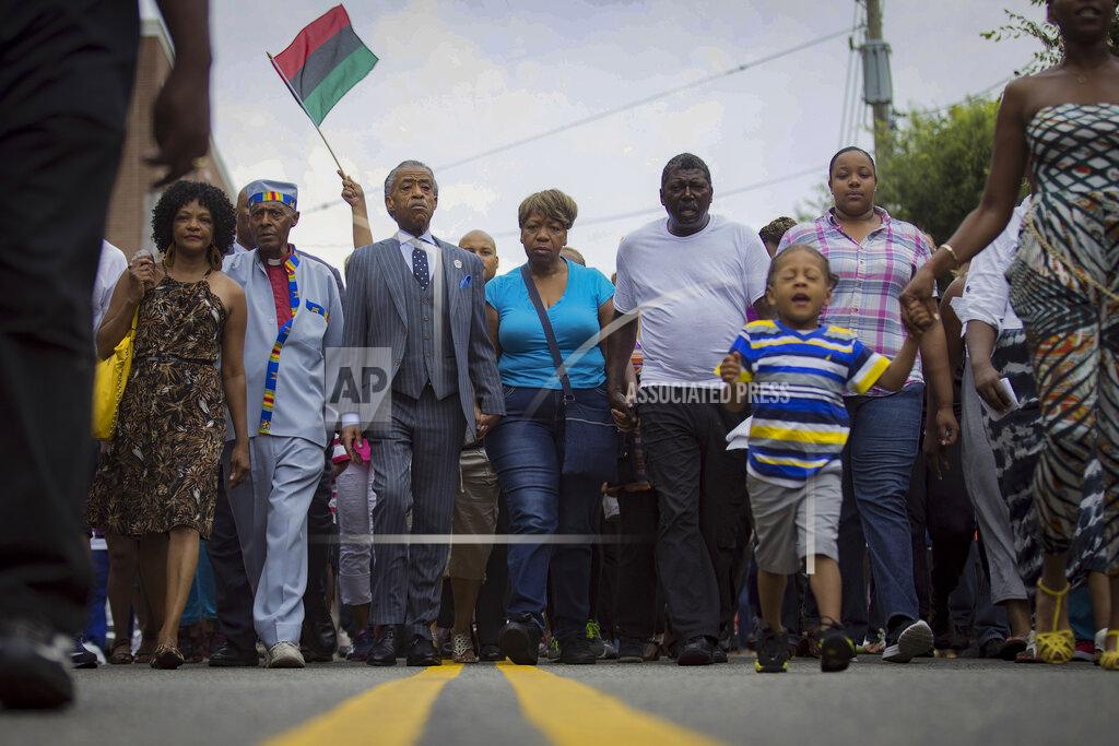 John Minchillo FILE - In this July 19, 2014, file photo, the Rev. Al Sharpton, third from left, and members of the family of Eric Garner, who died after a police chokehold, march toward the site of his death in the Staten Island borough of New York. For more than three decades, Sharpton, 65, has been a fierce advocate for Black American families seeking justice in the wake of violence and countless incidents that highlight systemic racism. (AP Photo/John Minchillo, File)
