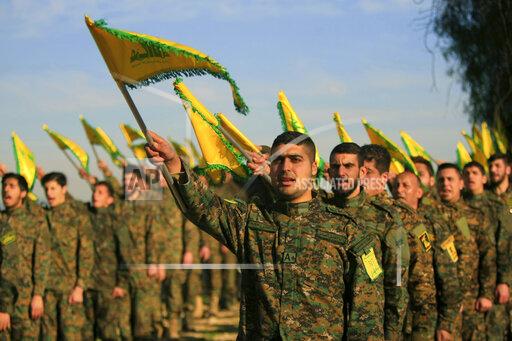 FILE - In this Feb. 13, 2016 file photo, Hezbollah fighters hold flags as they attend the memorial of their slain leader Sheik Abbas al-Mousawi, who was killed by an Israeli airstrike in 1992, in Tefahta village, south Lebanon. Hezbollah leader Hassan Nasrallah’s boast that he has 100,000 armed fighters that can be deployed against internal rivals came as a surprise to many Lebanese, not least because it was addressed to a domestic audience rather than the group’s archenemy Israel. Experts say the number — almost 20,000 more than the Lebanese army — is an exaggeration but is likely to further ratchet up anxiety of a return to sectarian fighting in the small country roiled by a series of devastating crises. (AP Photo/Mohammed Zaatari, File)