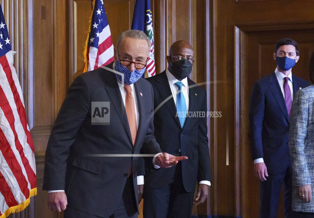 J. Scott Applewhite On the first full day of the Democratic majority in the Senate, Majority Leader Chuck Schumer, D-N.Y., left, is joined by Sen. Raphael Warnock, D-Ga., center, and Sen. Jon Ossoff, D-Ga., during a press event at the Capitol in Washington, Thursday, Jan. 21, 2021. The pivotal Georgia runoff election this month was decisive in handing Democrats the majority in the Senate. (AP Photo/J. Scott Applewhite)