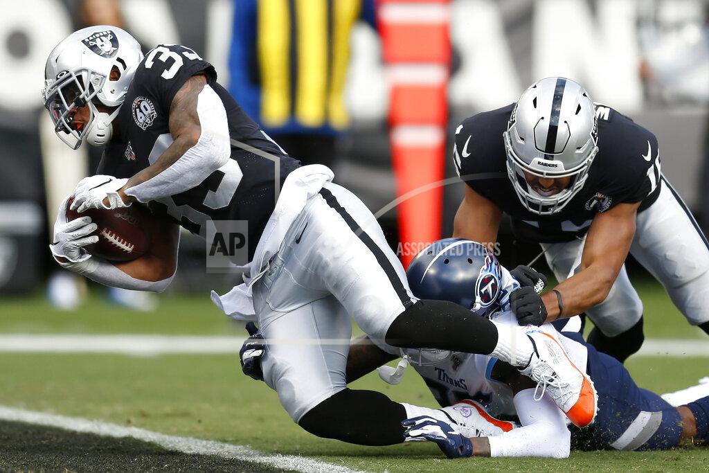 D. Ross Cameron Oakland Raiders running back DeAndre Washington (33) scores a touchdown past Tennessee Titans defensive back Tramaine Brock during the first half of an NFL football game in Oakland, Calif., Sunday, Dec. 8, 2019. (AP Photo/D. Ross Cameron)