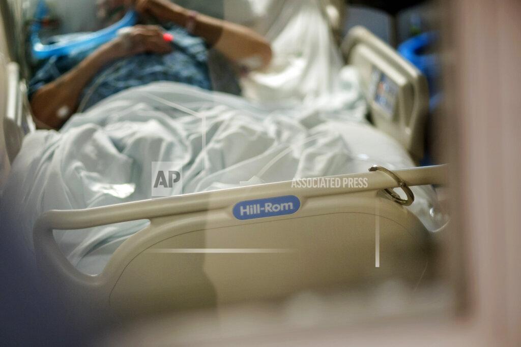 David Goldman An inmate from a nearby prison is shackled to the bed as he is treated with a ventilator for COVID-19 inside the intensive care unit at Kent Hospital, Monday, Dec. 28, 2020, in Warwick, R.I. Kent hospital opened a field hospital on Nov. 30, just before Rhode Island's infection rate became the highest in the world. Kent Hospital was using all its beds for its sickest COVID-19 patients, and needed somewhere for the overflow. (AP Photo/David Goldman)