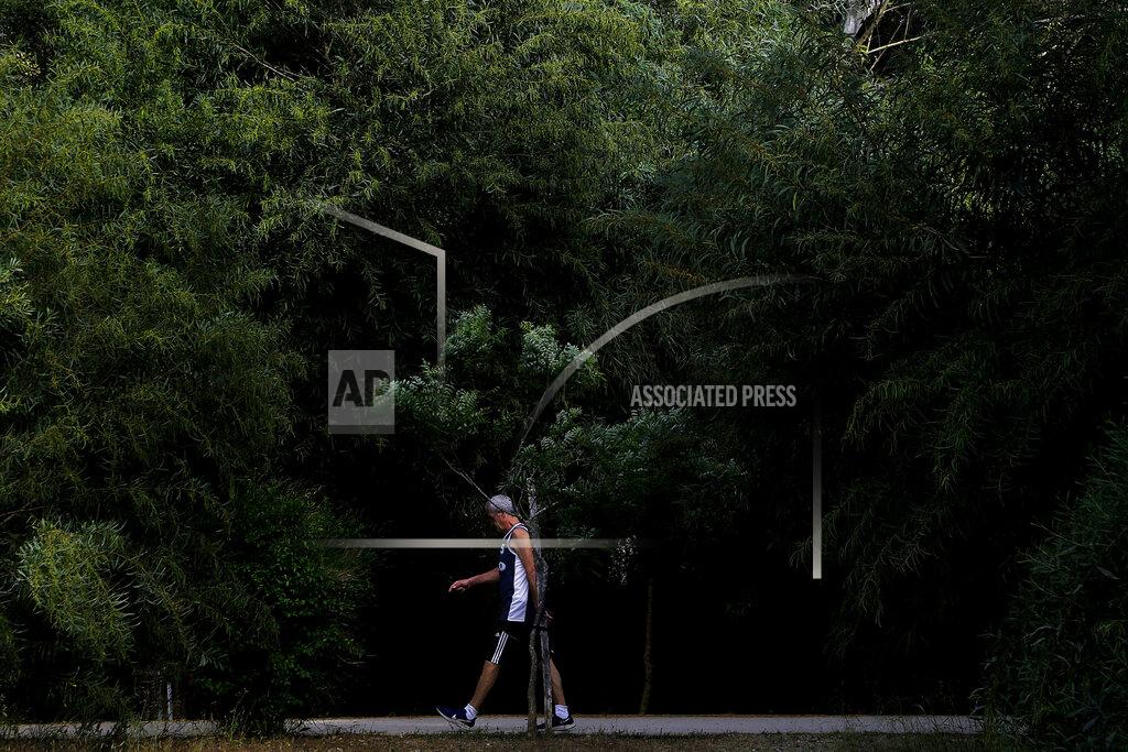 Petros Karadjias A man walks at a main park amid COVID-19 pandemic restrictions government in central capital Nicosia, Cyprus, Thursday, May 6, 2021. Cyprus has unveiled a phased rollback of COVID-19 lockdown restrictions over the next month including a shortened curfew and a reopening of all schools next week, but will enforce the compulsory display of proof of vaccination, virus testing or convalescence from the disease in areas were people gather in numbers, including restaurants and churches. (AP Photo/Petros Karadjias)