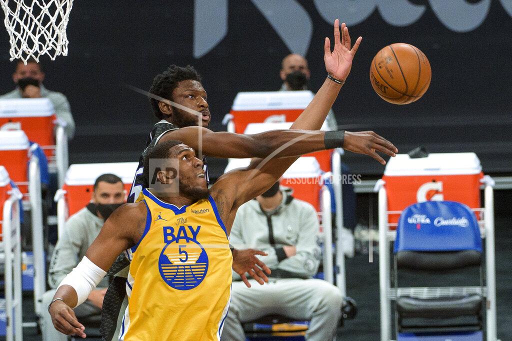 Randall Benton Golden State Warriors center Kevon Looney (5) and Sacramento Kings forward Chimezie Metu reach for a rebound during the first quarter of an NBA basketball game in Sacramento, Calif., Thursday, March 25, 2021. (AP Photo/Randall Benton)