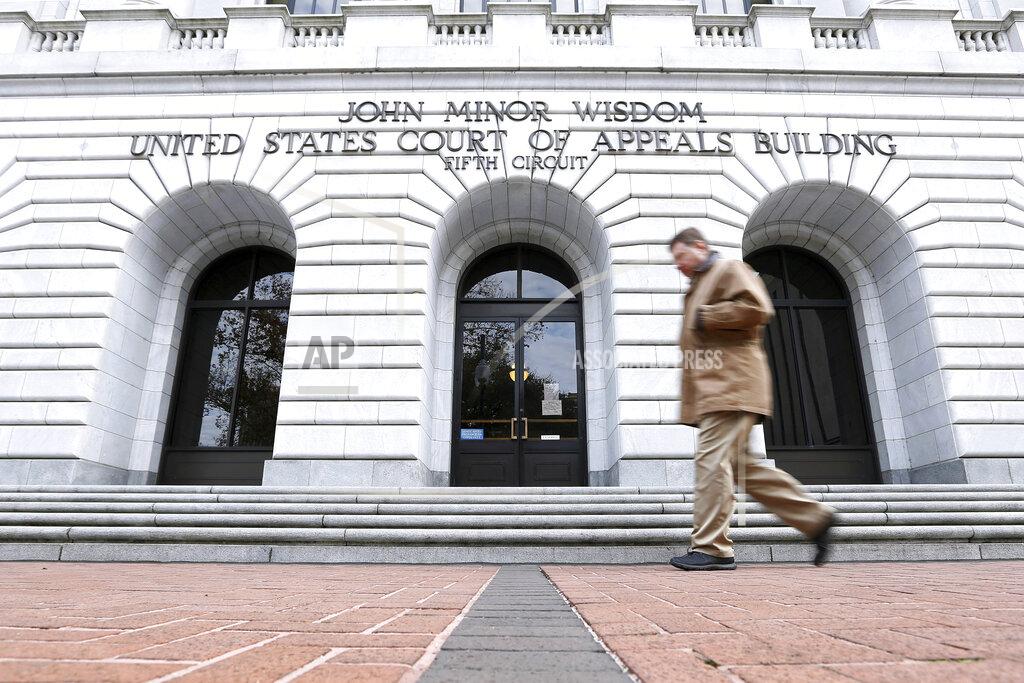 Jonathan Bachman FILE - In this Jan. 7, 2015, file photo, a man walks in front of the 5th U.S. Circuit Court of Appeals in New Orleans. Texas should be allowed to halt a common second-trimester abortion procedure, the state's lawyers told a federal appeals court Thursday, Jan. 21, 2021, in a hearing punctuated by debates over fetal pain and the rights of women to medically safe abortion. (AP Photo/Jonathan Bachman, File)