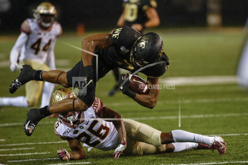 Wake Forest wide receiver Scotty Washington dives over Florida State defensive back Asante Samuel Jr. (26) after a catch in the second half of an NCAA college football game in Winston-Salem, N.C., Saturday, Oct. 19, 2019. Wake Forest won 22-20. (AP Photo/Nell Redmond)
