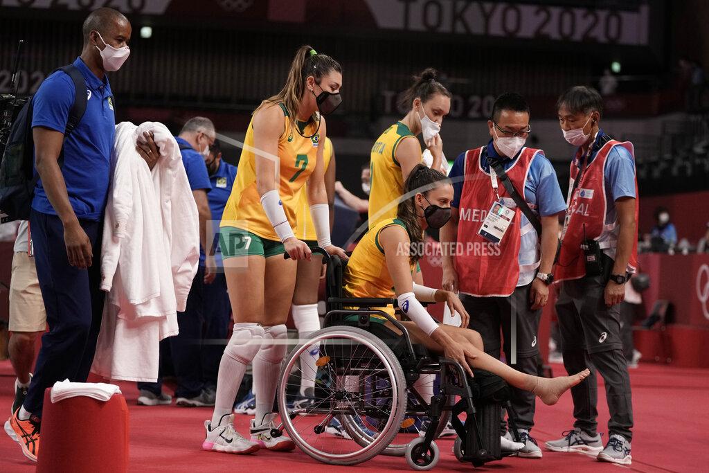 Manu Fernandez Brazil's Rosamaria Montibeller, #7, pushes in a wheelchair her teammate Macris Fernanda Silva Carneiro who was injured during a women's volleyball preliminary round pool A match against Japan, at the 2020 Summer Olympics, Thursday, July 29, 2021, in Tokyo, Japan. (AP Photo/Manu Fernandez)