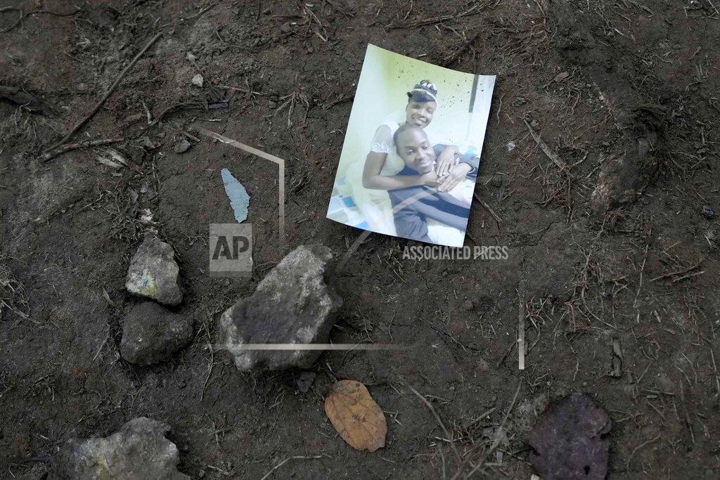 Fernando Vergara A family snapshot lays on the ground near a trail used by migrants, near Acandi, Colombia, Wednesday, Sept. 15, 2021. The migrants, mostly Haitians, are on their way to crossing the Darien Gap from Colombia into Panama dreaming of reaching the U.S. (AP Photo/Fernando Vergara)