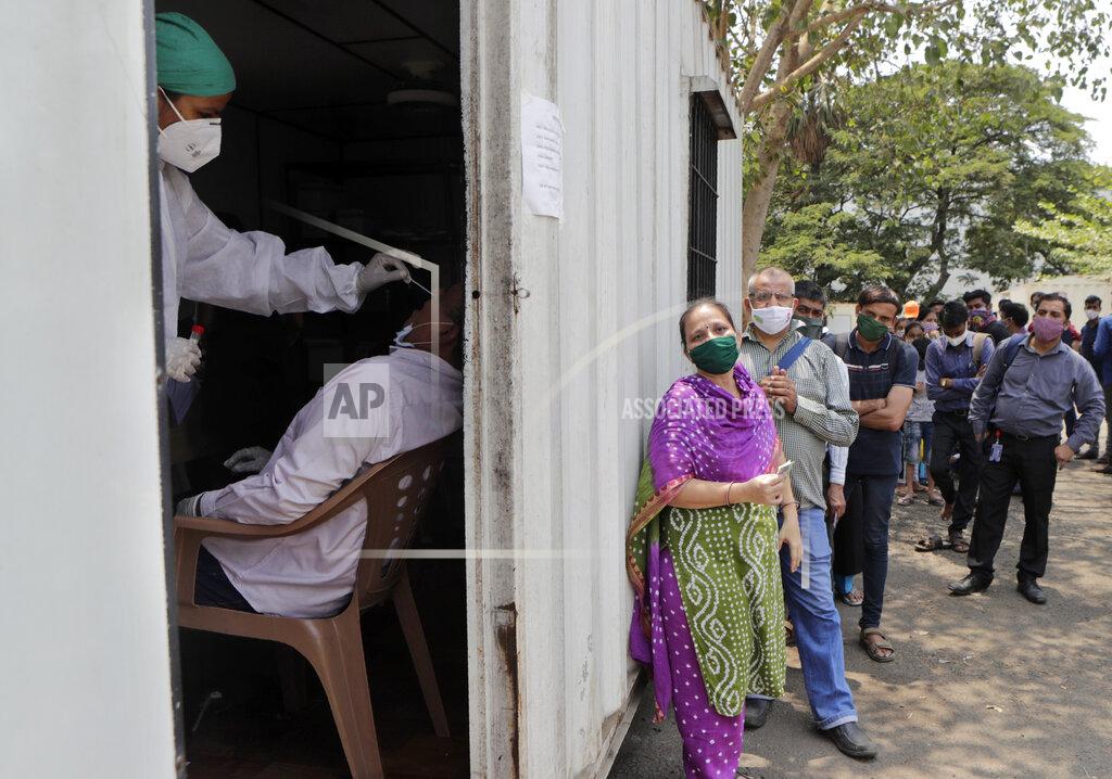 Rajanish Kakade FILE - In this May 6, 2021, file photo, a health worker takes a nasal swab sample of a person to test for COVID-19 as others wait for their turn outside a field hospital in Mumbai, India. The World Health Organization said Monday, May 10, that a worrisome variant was first detected in India may spread more easily. Scientists are still trying to figure out if it resulted in the terrifying surge of infections in the nation, and looking to see if this could this happen elsewhere. (AP Photo/Rajanish Kakade, File)