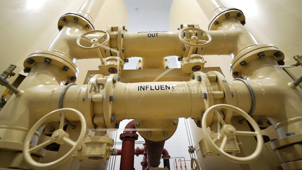 Charles Krupa In this Friday, Aug. 14, 2020, photo valves and piping are labeled backwash out and influent in Merrimack, N.H., in an under-construction town water filtration site for two contaminated wells, which are about two miles from the Saint-Gobain plastics factory. (AP Photo/Charles Krupa)
