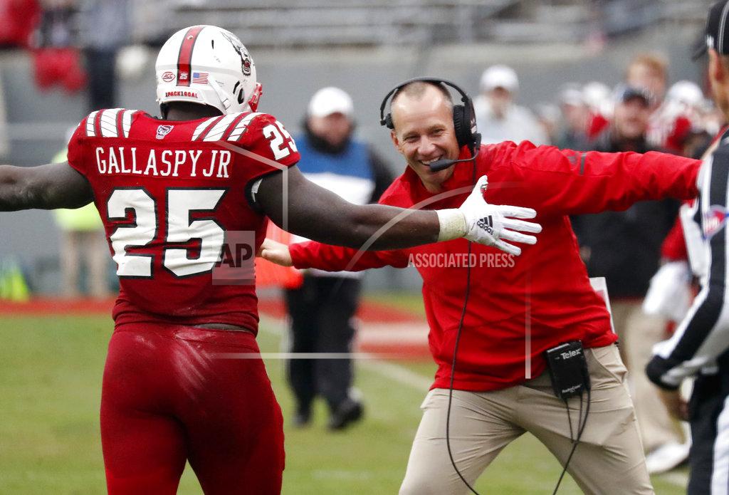 Chris Seward North Carolina State's Reggie Gallaspy II (25) is congratulated by head coach Dave Doeren after he ran for a long gain during the second half of NCAA college football game in Raleigh, N.C., Saturday, Dec. 1, 2018. (AP Photo/Chris Seward)