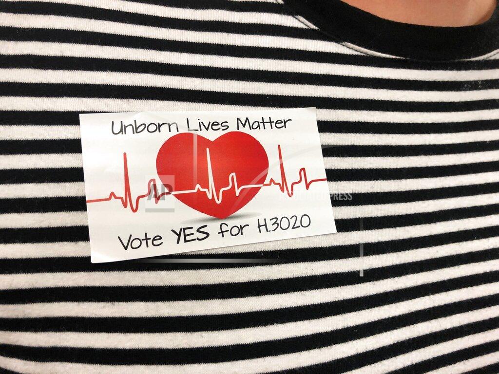 Jeffrey Collins FILE - In this Tuesday, Sept. 10, 2019, file photo, supporters of a bill banning abortions in South Carolina after a fetal heartbeat is detected wore similar stickers at a state Senate subcommittee public hearing in Columbia, S.C. The assertion by proponents that abortion as early as six weeks into pregnancy “stops a beating heart” was arguably the stroke of political genius that helped so-called “heartbeat bills” defy constitutional concerns to become law in 12 states. (AP Photo/Jeffrey Collins, File)