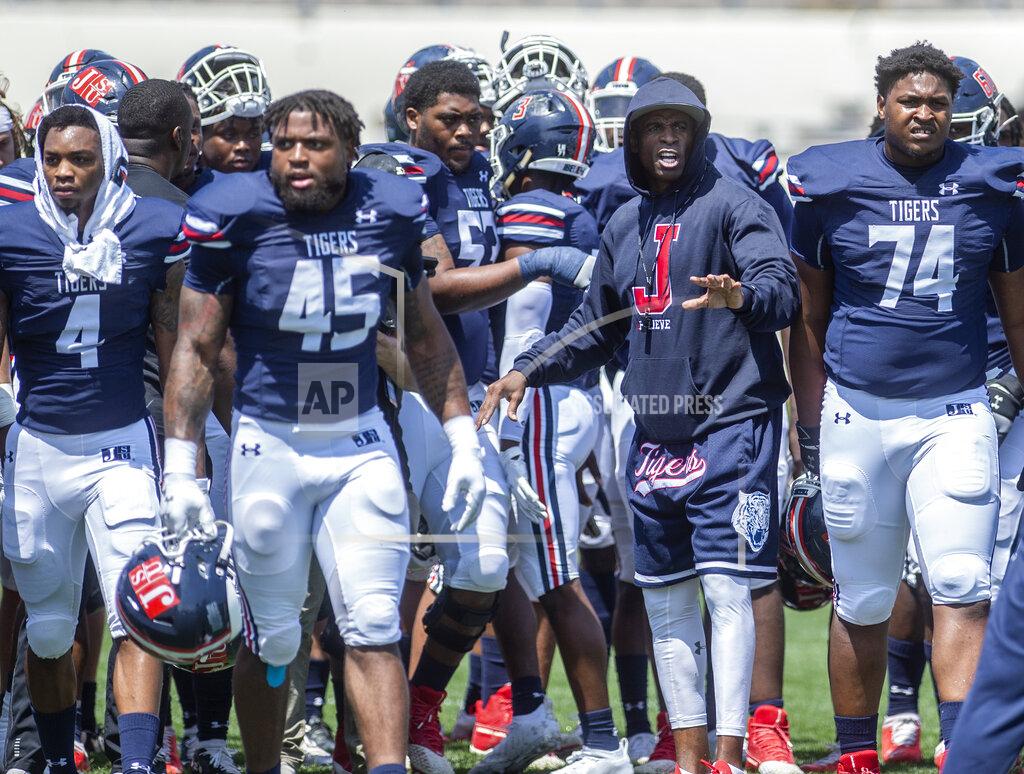 Eric Shelton Jackson State head football coach Deion Sanders, left, talks to his team as they prepare to play Alabama A&M in an NCAA college football game, Saturday, April 10, 2021, at Veterans Memorial Stadium in Jackson, Miss. (Eric Shelton/The Clarion-Ledger via AP)