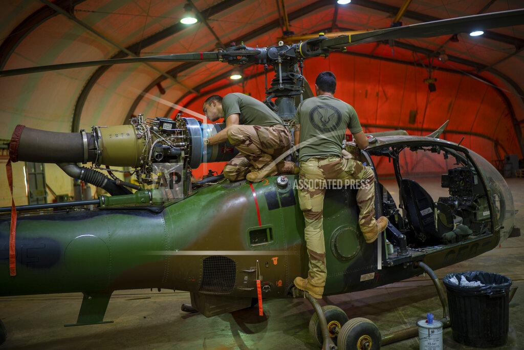 Uncredited French Barkhane force mechanics maintain a Gazelle combat helicopter tag their base in Gao, Mali Tuesday June 8, 2021. After France suspended joint military operations with Malian forces after the junta led by Col. Assimi Goita retook control of Mali's transitional government May 24 2021, French President Emmanuel Macron announced at a press conference Thursday June 10, 2021 That operation Barkhane would end and be replaced by support for local partners and counter terrorism. (AP Photo/Jerome Delay)