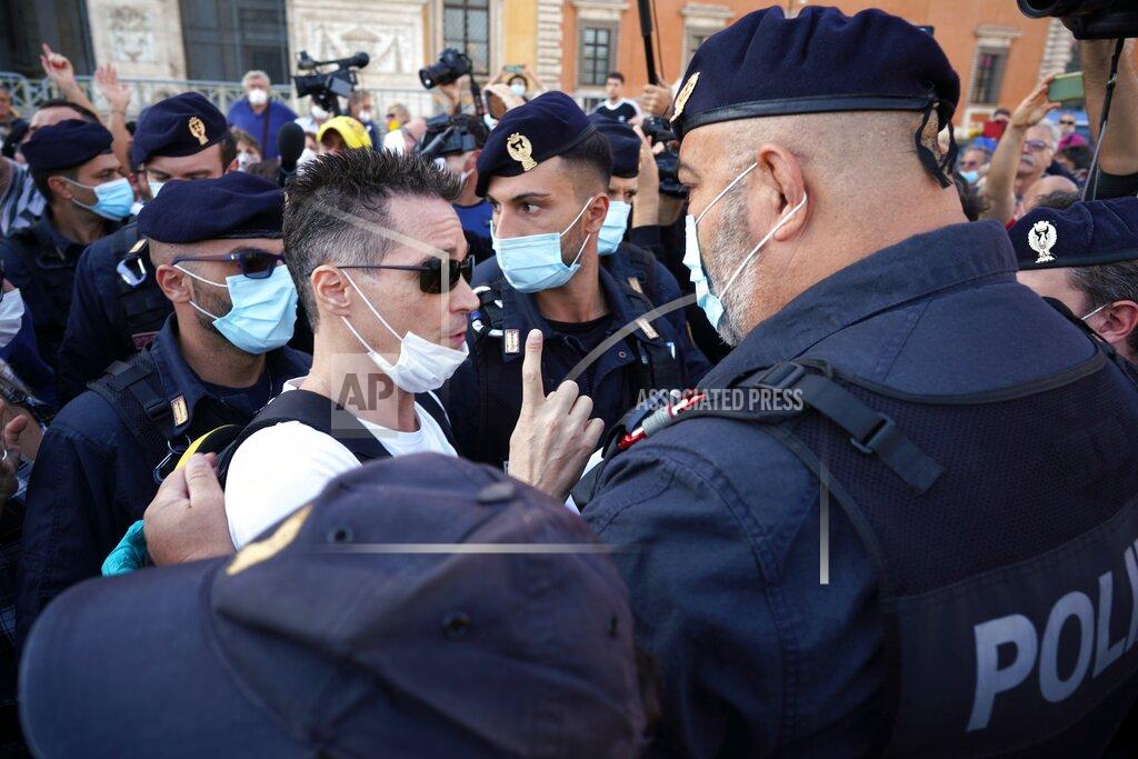 Andrew Medichini A man is taken away by police during a protest against the government restriction measures to curb the spread of COVID-19, in Rome, Saturday, Oct. 10, 2020. (AP Photo/Andrew Medichini)