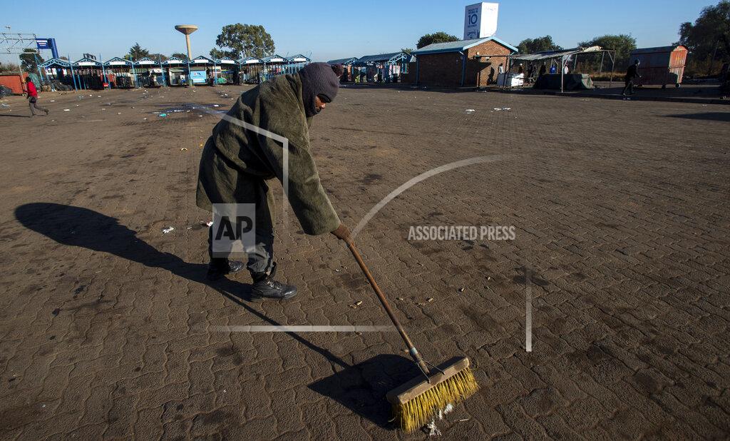 Themba Hadebe A worker sweeps the floor at a taxi rank in Katlehong, South Africa, Monday, June 22, 2020, as taxi drivers affiliated to the SA National Taxi Council (Santaco) protested against what it believes to be insufficient government relief offered to the industry. South Africa’s largest city, Johannesburg, has been hit by a strike by mini-bus taxis, preventing many thousands of people from getting to work on Monday, as the country reopens its economy even as cases of COVID-19 are increasing. (AP Photo/Themba Hadebe)