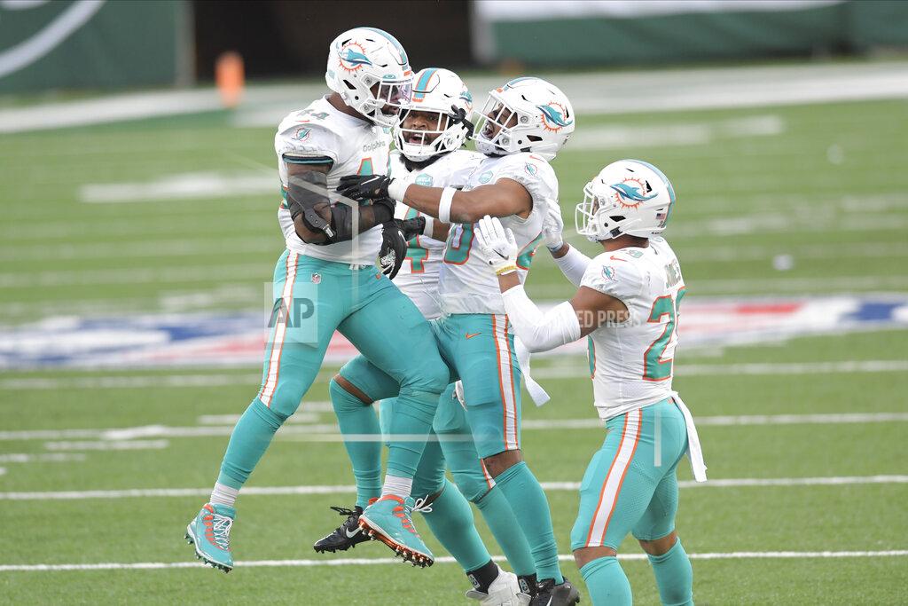 Bill Kostroun Miami Dolphins' Elandon Roberts, left, celebrates a stop with teammates during the second half of an NFL football game against the New York Jets, Sunday, Nov. 29, 2020, in East Rutherford, N.J. (AP Photo/Bill Kostroun)