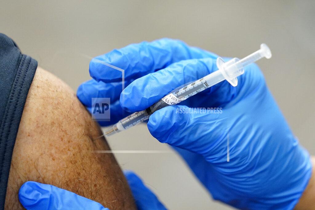FILE - In this Jan. 5, 2021, file photo, a healthcare worker receives a second Pfizer-BioNTech COVID-19 vaccine shot in Southfield, Mich. On Friday, Jan. 8, 2021, The Associated Press reported on stories circulating online incorrectly asserting that COVID-19 vaccines that rely on messenger RNA technology will teach the body to attack itself, leading to autoimmune disease. The mRNA vaccines for COVID-19 contain a genetic code that trains the immune system to recognize the spike protein on the surface of the virus to generate an immune response and fight it. A lack of understanding around how mRNA vaccines work has led to a flurry of misinformation around the vaccines. (AP Photo/Paul Sancya, File)