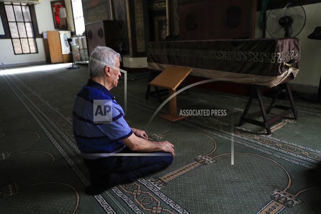 Hussein Malla The father of Ibrahim Harb, 35, a Lebanese man who was critically injured in the massive explosion at Beirut's port last year and who died on Monday nearly 14 months after the blast, prays at a mosque next of his son's coffin in Beirut, Lebanon, Tuesday, Sept. 28, 2021. On August 4, 2020, hundreds of tons of ammonium nitrate, a highly explosive material used in fertilizers, ignited after a massive fire at the port. The death brings to at least 215 the number of people who have been killed by the blast, according to official records. (AP Photo/Hussein Malla)