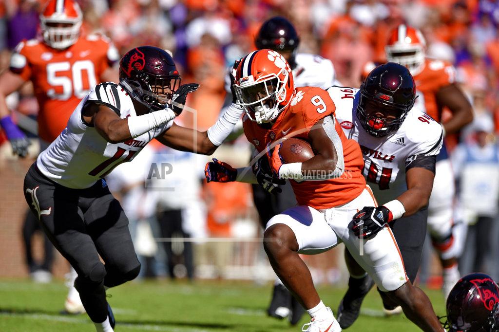 Richard Shiro Clemson's Travis Etienne rushes through Louisville's Dee Smith (11) and G.G. Robinson to score a touchdown during the first half of an NCAA college football game Saturday, Nov. 3, 2018, in Clemson, S.C. (AP Photo/Richard Shiro)