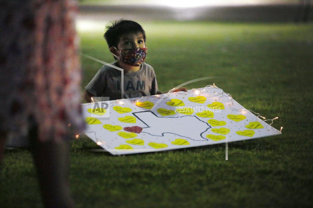 Briana Sanchez In this Thursday, July 30, 2020 photo, Noah Reyes looks at the 23 luminarias in Cleveland Square Park honoring the victims of the Aug. 3, 2019 El Paso shooting, in downtown El Paso. (Briana Sanchez/The El Paso Times via AP)