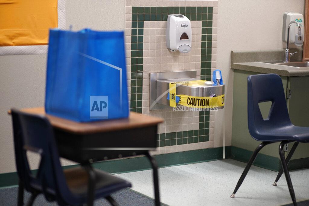 A water fountain is taped off in preparation for students to return at Dean Petersen Elementary School, Wednesday, Feb. 24, 2021, in Las Vegas. School administrators in Las Vegas say they plan a phased return to classrooms in coming weeks for middle- and high school students in the nation's fifth-largest school district. (AP Photo/John Locher)