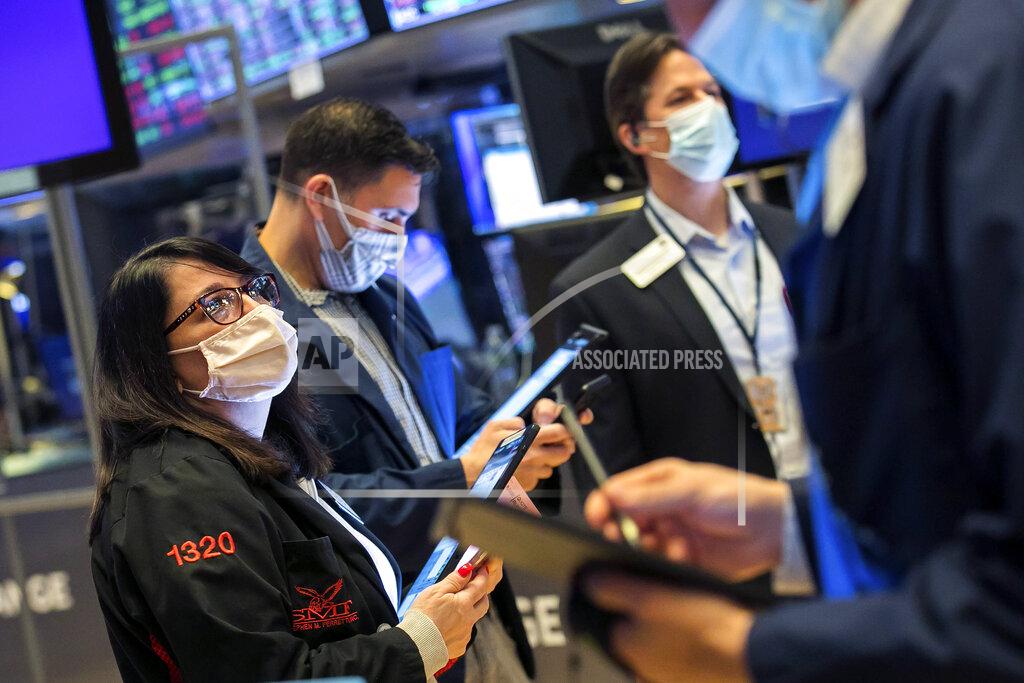 Courtney Crow In this photo provided by the New York Stock Exchange, Phyllis Arena Woods, left, works with other traders on the floor, Friday, Feb 26, 2021. Stocks wobbled between small gains and losses on Wall Street Friday as rising technology stocks offset a slide in banks and energy companies. (Courtney Crow/New York Stock Exchange via AP)