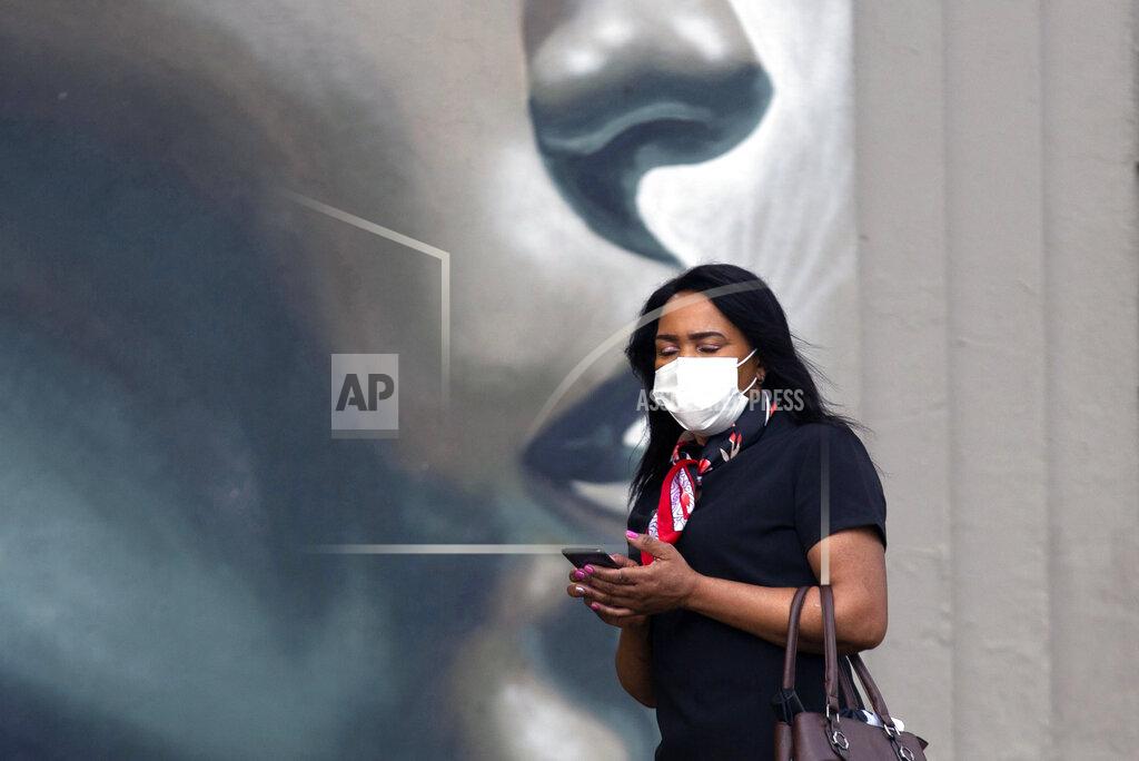 Denis Farrell A pedestrian wearing a mask to protect against COVID-19 passes a wall mural on a sidewalk in Johannesburg, Wednesday, Feb. 24, 2021. In Finance Minister's budget speech in Parliament, Tito Mboweni said South Africa plans to spend dollars 712 million to vaccinate some 67% of its 60 million people to control the country's COVID-19 battle and get the economy to rebound from its decline of 7.2% last year. (AP Photo/Denis Farrell)