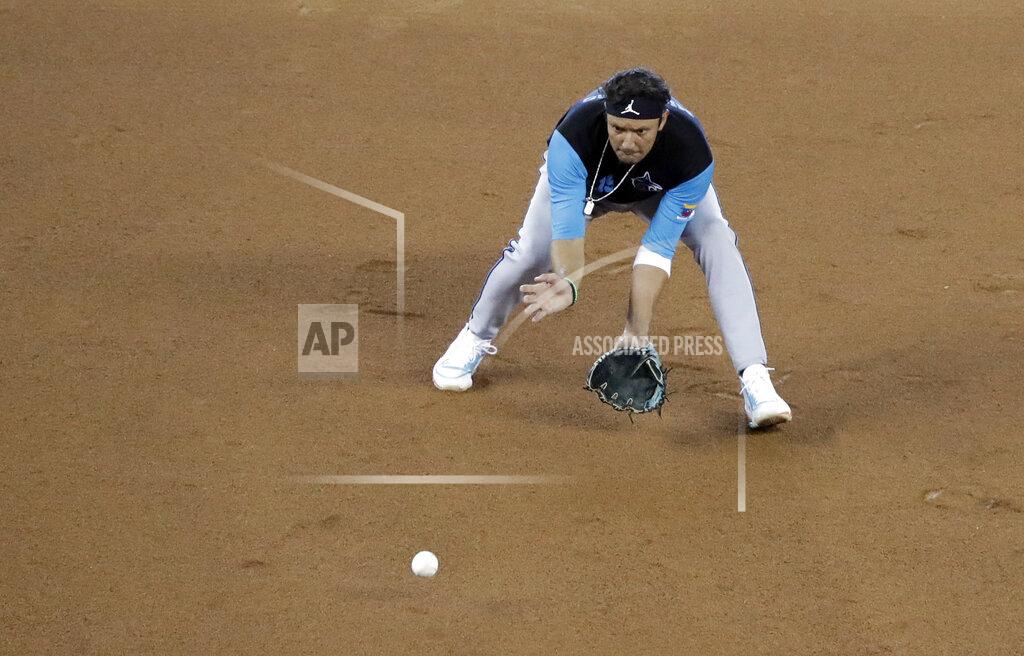 Wilfredo Lee FILE - In this July 5, 2020, file photo, Miami Marlins shortstop Miguel Rojas fields a ball during a baseball workout at Marlins Park in Miami. Rojas talked Monday, July 20, 2020, about the ways this season will be different, with bench players sitting in the stands during games and no clubhouse meals afterward. Another change: Rojas believes the Marlins will be good. (AP Photo/Wilfredo Lee, File)