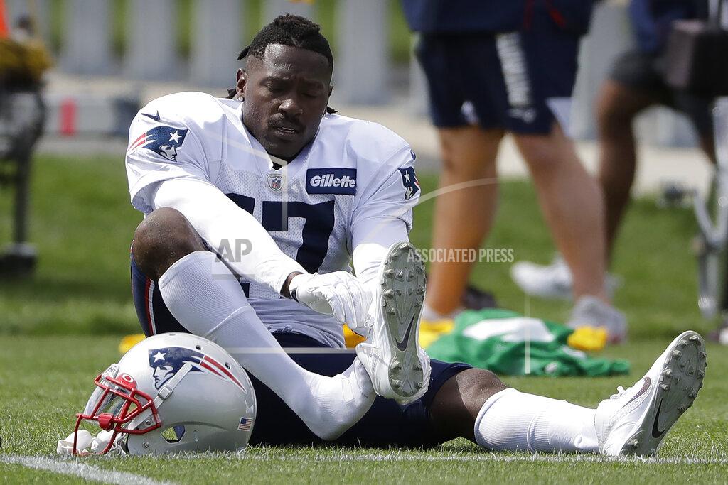 New England Patriots wide receiver Antonio Brown puts on his shoe during an NFL football practice, Wednesday, Sept. 18, 2019, in Foxborough, Mass. (AP Photo/Steven Senne)